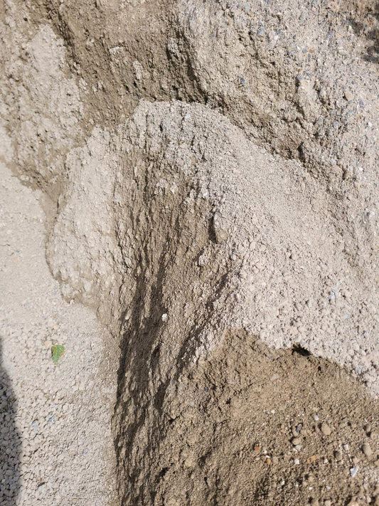 Grau-bräunliche Wassergebundene Wegedecke, leicht gehäuft.