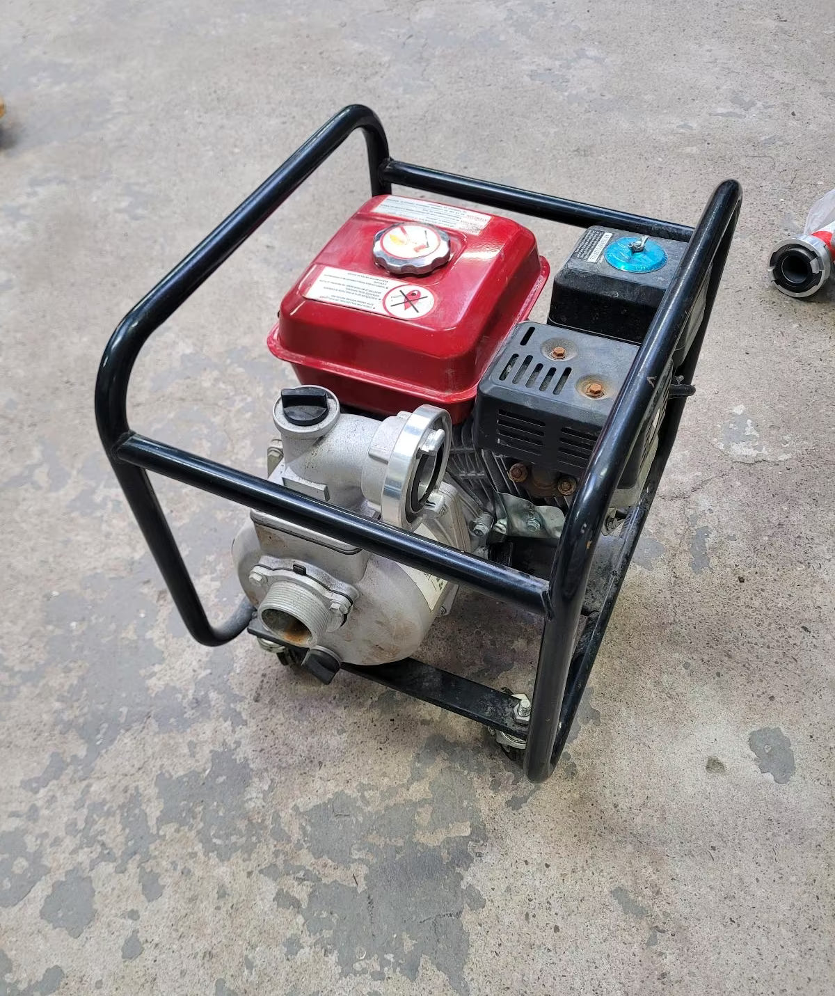 Eine schwarze Benzin Wasserpumpe mit einem Metallrahmen, in dem der Motor eingelassen ist.