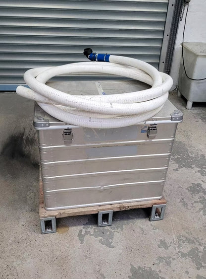 Die Benzin Wasserpumpe mit Zubehör in einer Kiste, obenaufliegend ein Kunststoffrohr.