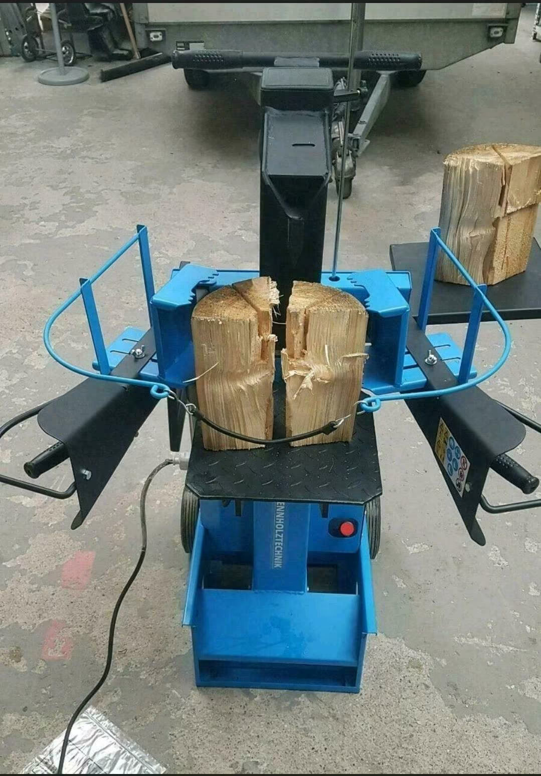 Schwarz-blauer Holzspalter mit Rollen.
