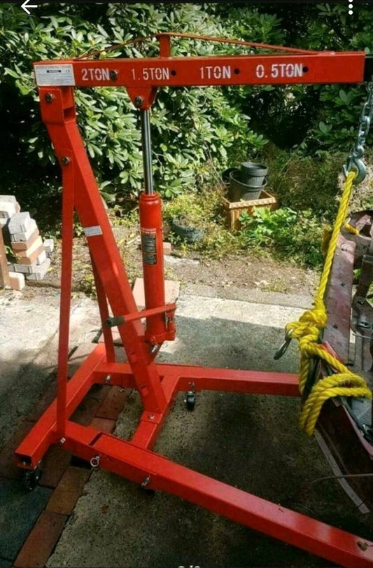 Ein roter, circa menschengroßer Lastenkran für beispielsweise Motoren.