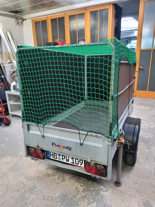 Ein offener Anhänger, hier mit drei Seitenwänden und einem grünen Netz über Dach und Öffnung hinten gespannt.