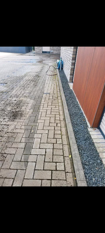Man sieht einen gepflasterten Weg, auf dem eine gereinigte Spur des Pflasterreinigungsgeräts zu sehen ist, während daneben noch alles dreckig ist.