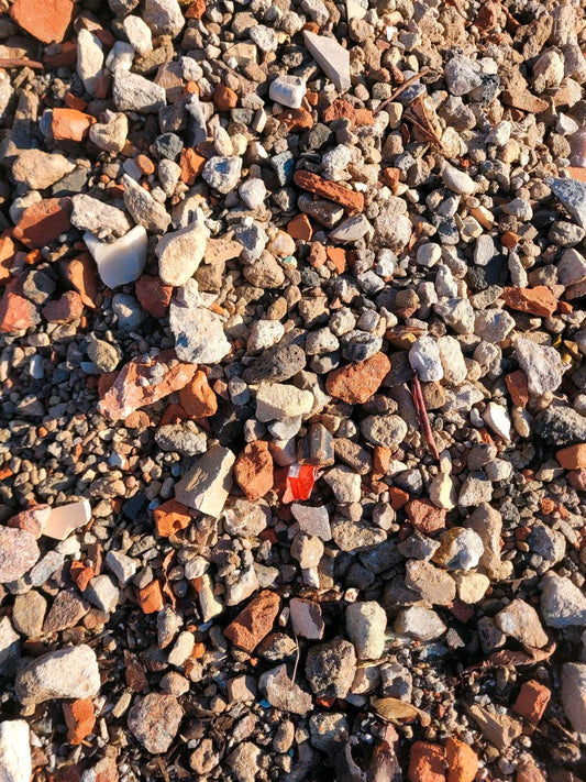 Bunter Recycling-Kies mit unterschiedlicher Struktur und Farbgebungen von Weiß, Grau, Orange und Braun.