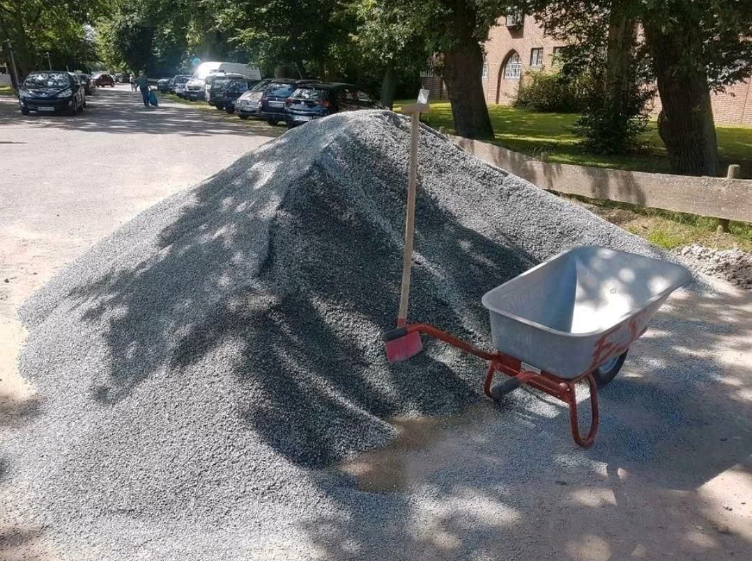 ein grauer Splitthaufen an einem Straßenrand