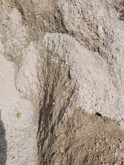 Grau-bräunliche Wassergebundene Wegedecke, leicht gehäuft.