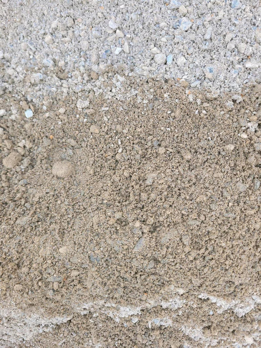 Eine grau-bräunliche Wassergebundene Wegedecke von nahem betrachtet.